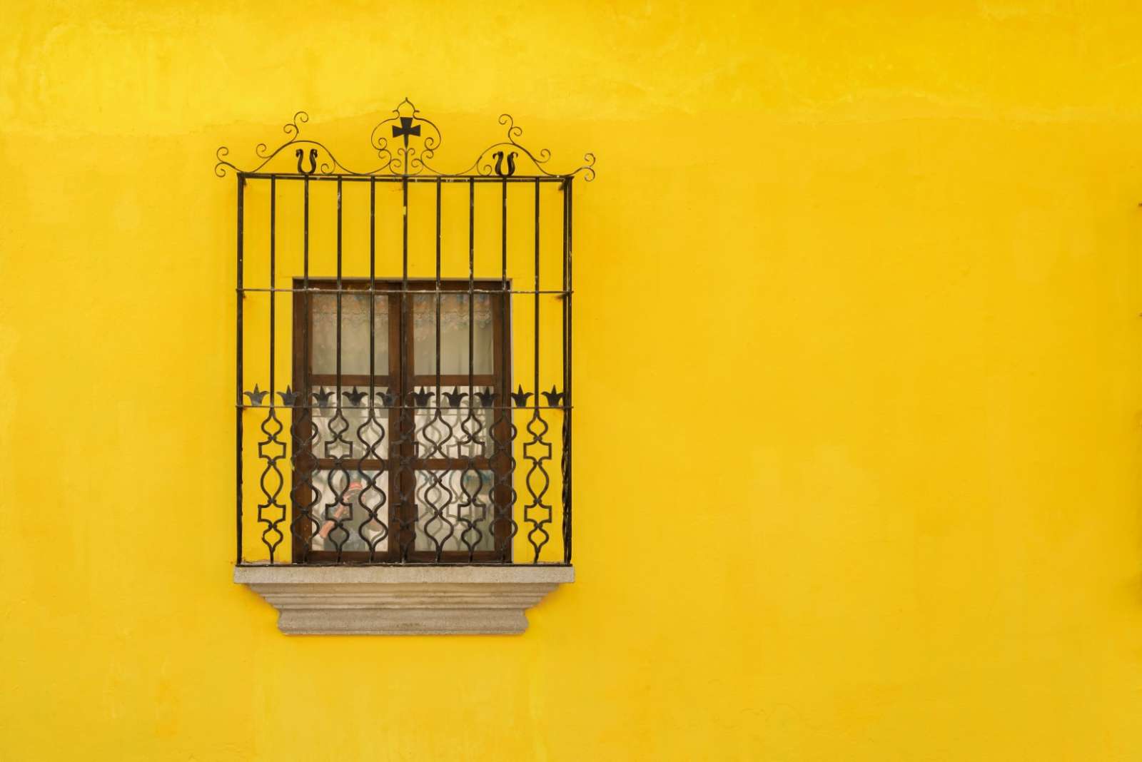 Window on yellow wall in Antigua, Guatemala