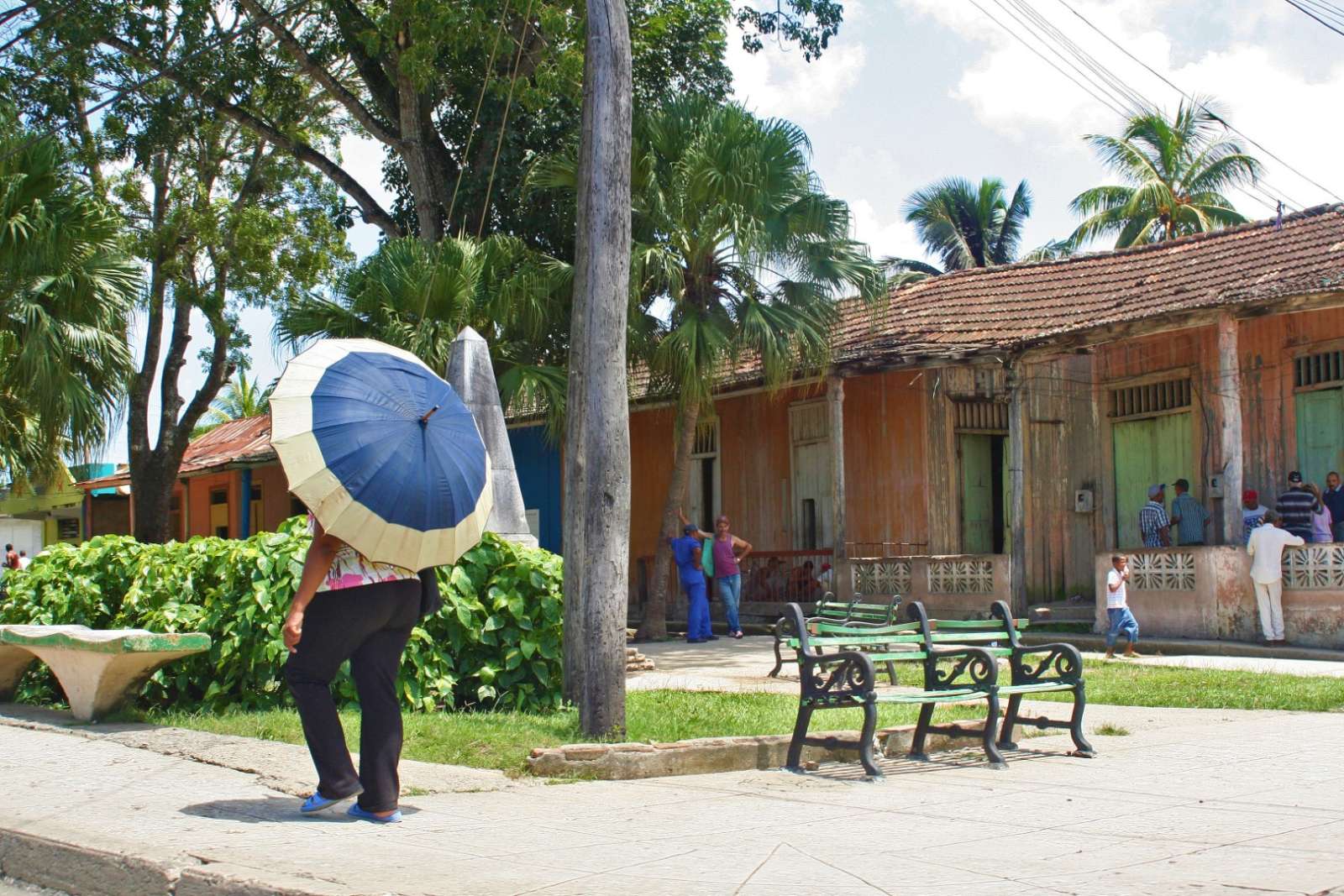 Woman with umbrella walking in Baracoa