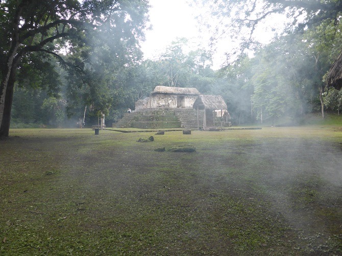 The Mayan ruins at Ceibal with the smoke of natural mosquito repellent