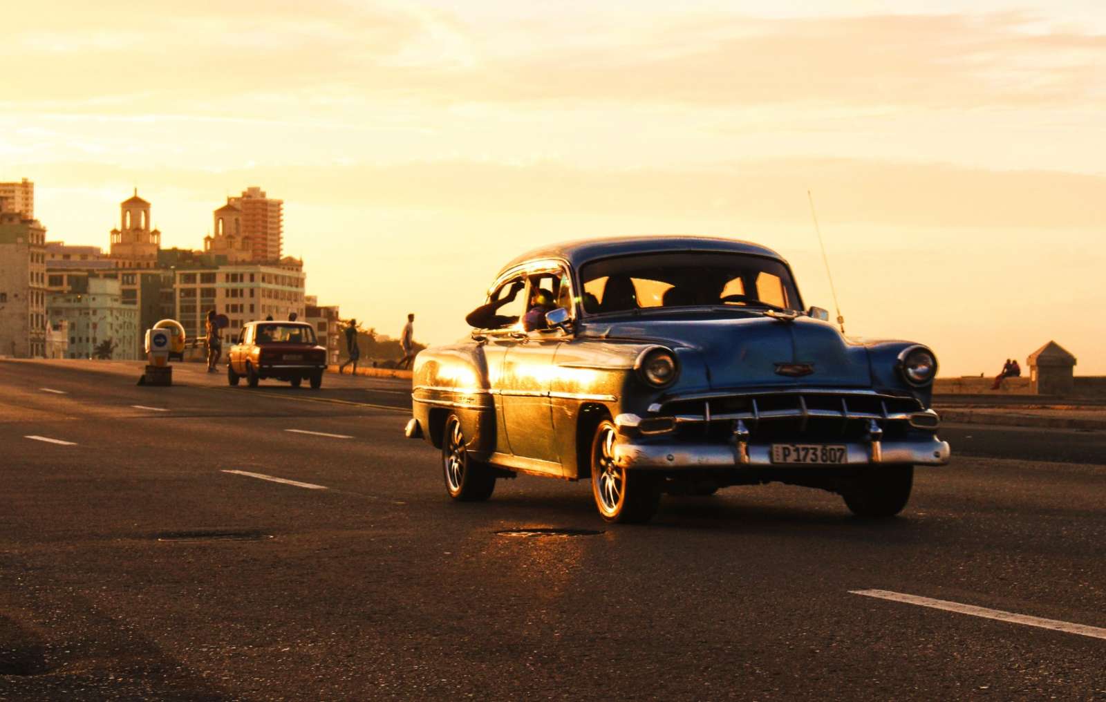 A classic car driving along Havana's seafront Malecon