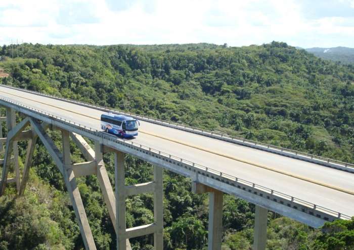 A coach driving over a bridge in Cuba