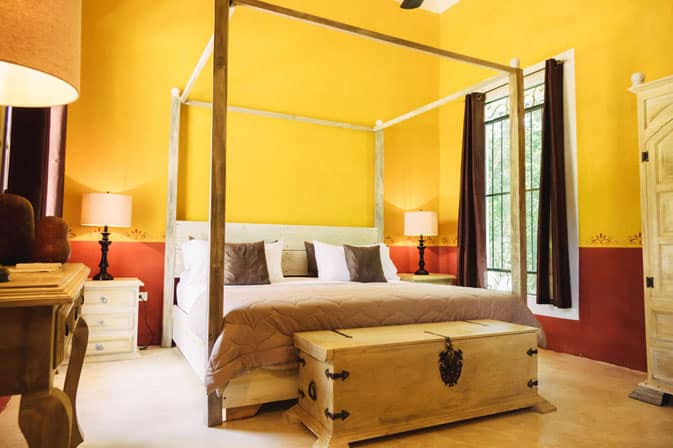 Bedroom with yellow walls at Hacienda Ticum near Izamal