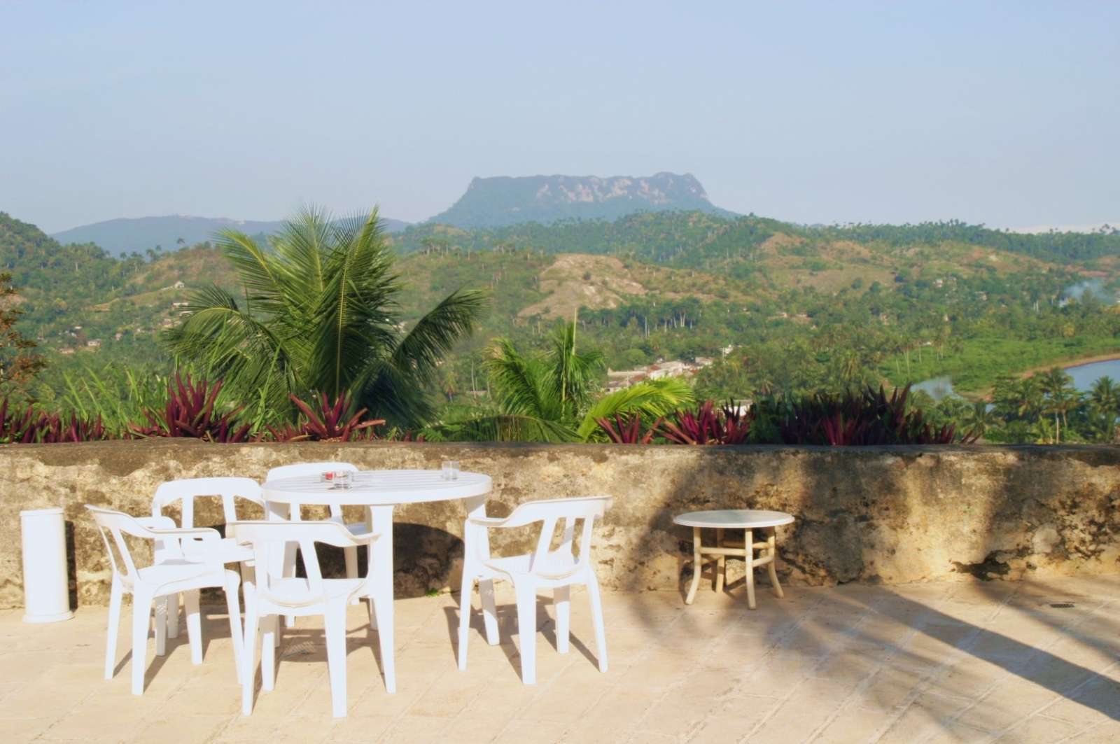 Table and chairs facing El Yunque at Hotel El Castillo