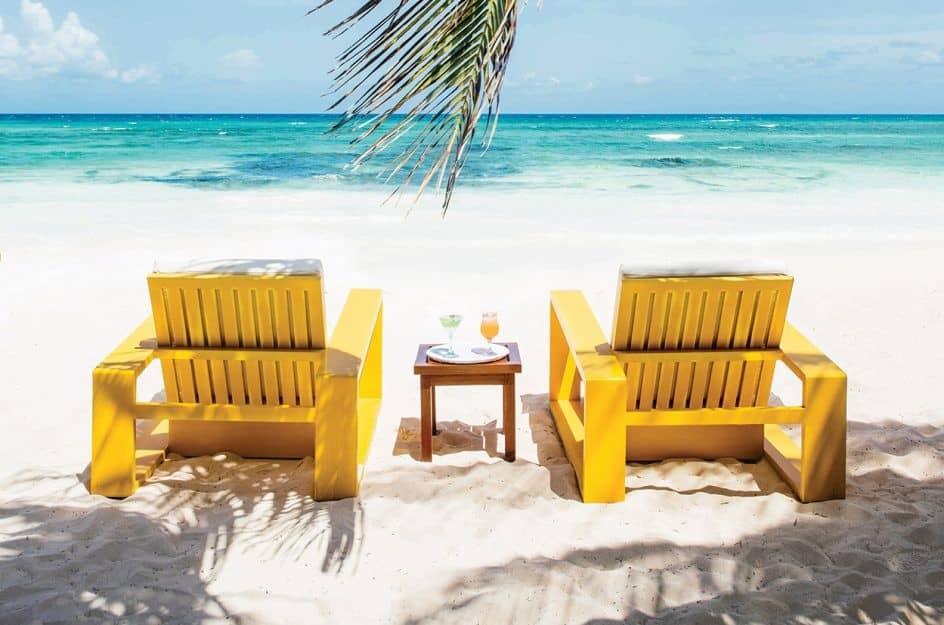 Two chairs facing the sea on the beach at Hotel Esencia