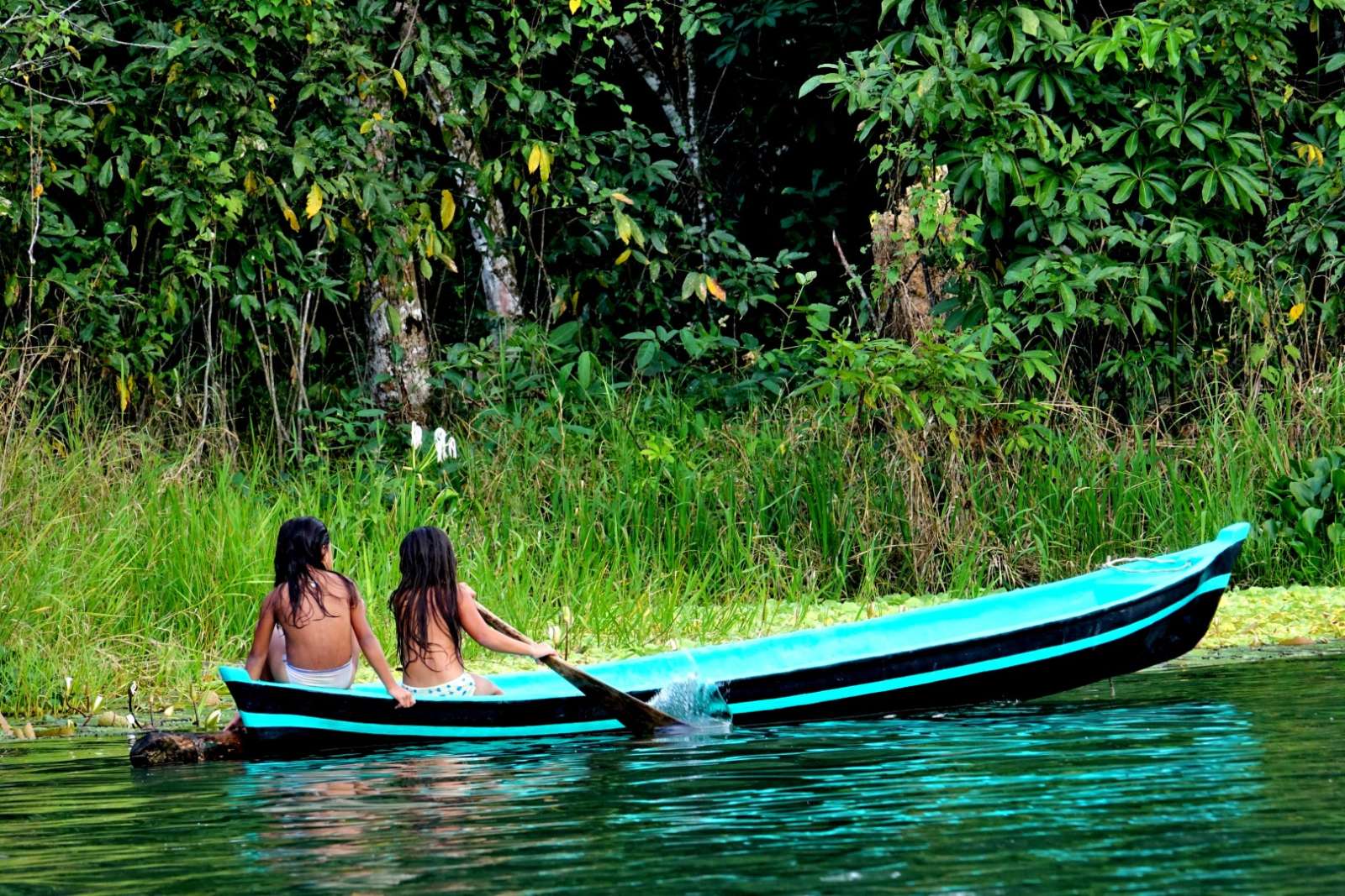 Two young girls in canoe on Rio Dulce, Guatemala