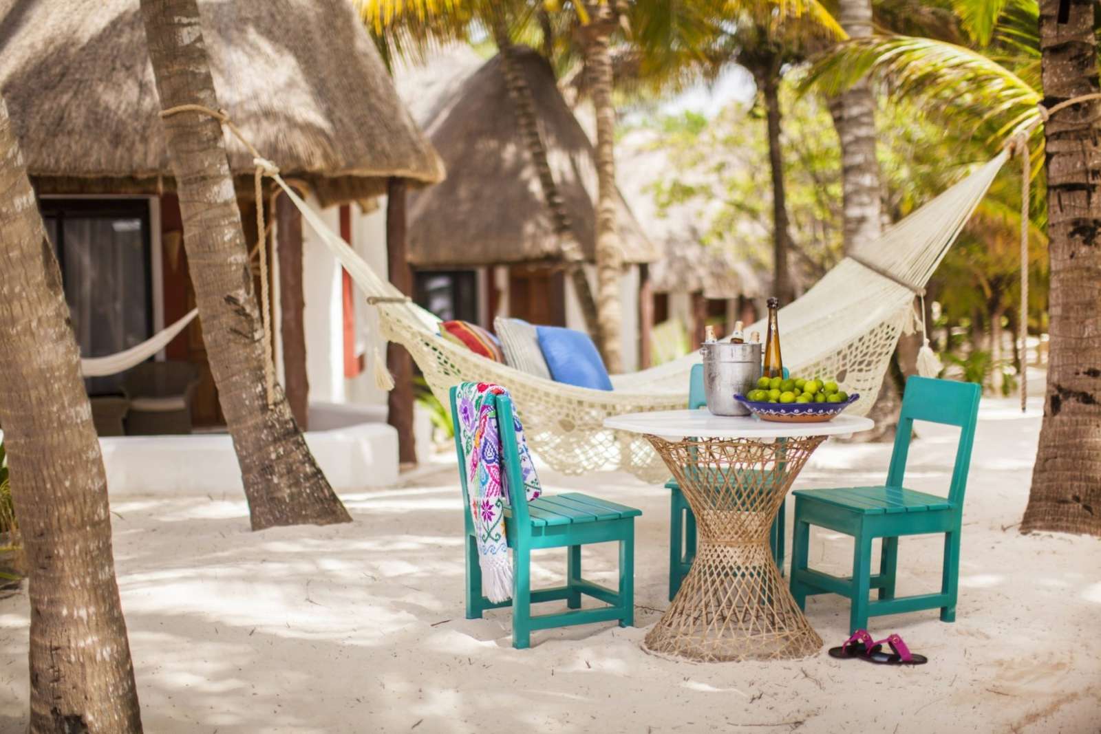 Table and hammock on beach at Mahekal Beach Resort