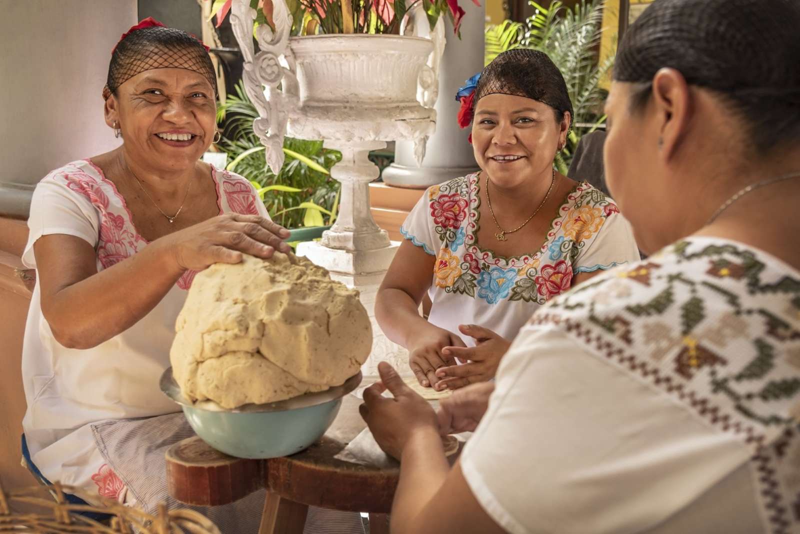 Three Mayan women making tortillas