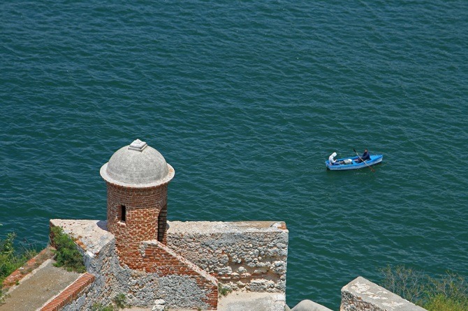 A small boat underneath the Morro Castle in Santiago de Cuba