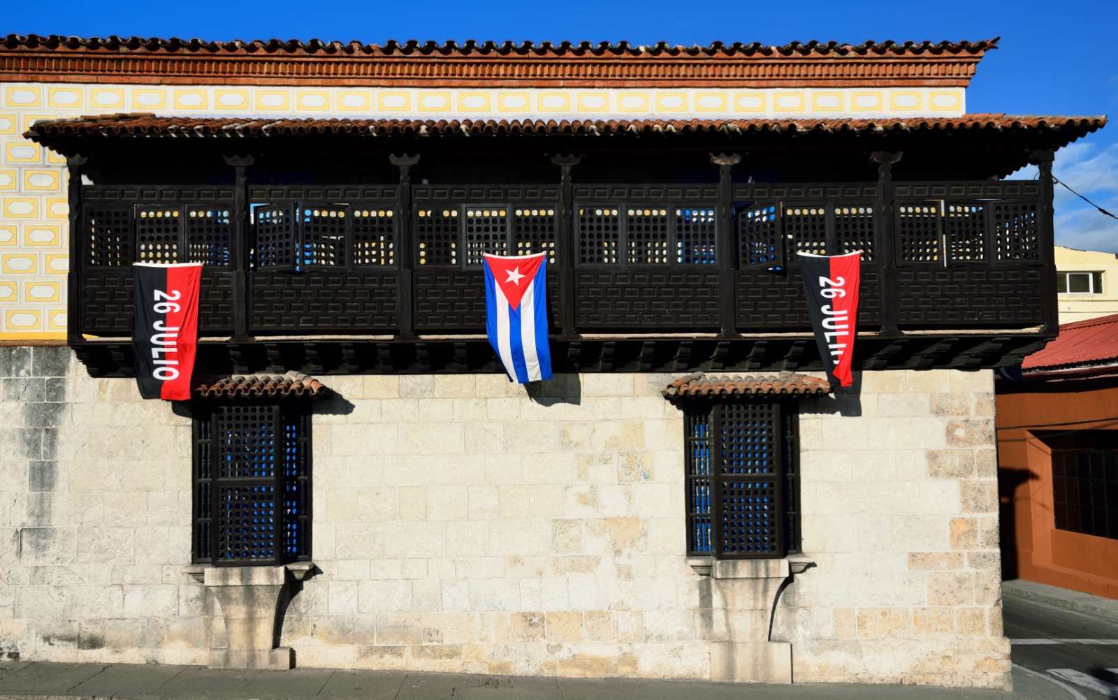 Flags on colonial building in Santiago de Cuba