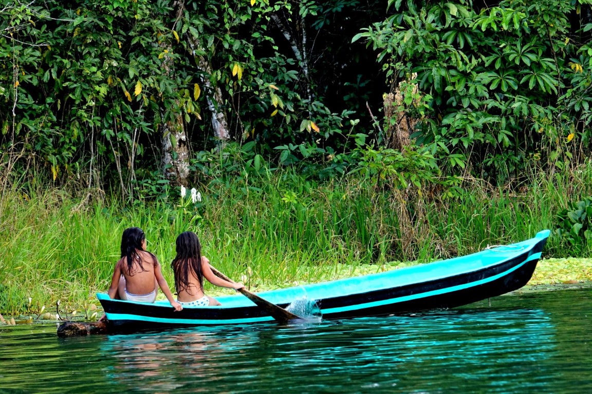 Two young girls in a canoe on the Rio Dulce