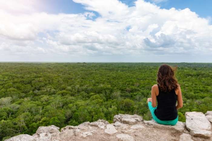 Woman on top of pyramid at Coba Mayan ruins