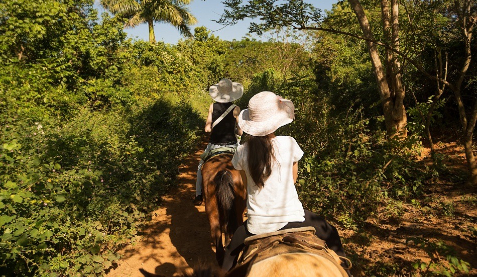 Family riding horses in Vinales Cuba