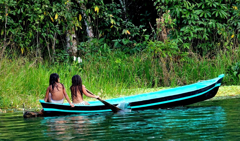 Two girls in a canoe on the Rio Dulce in Guatemala