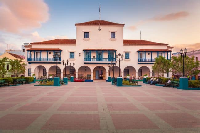 Colonial style white public building with red tiled roof and wooden balconies