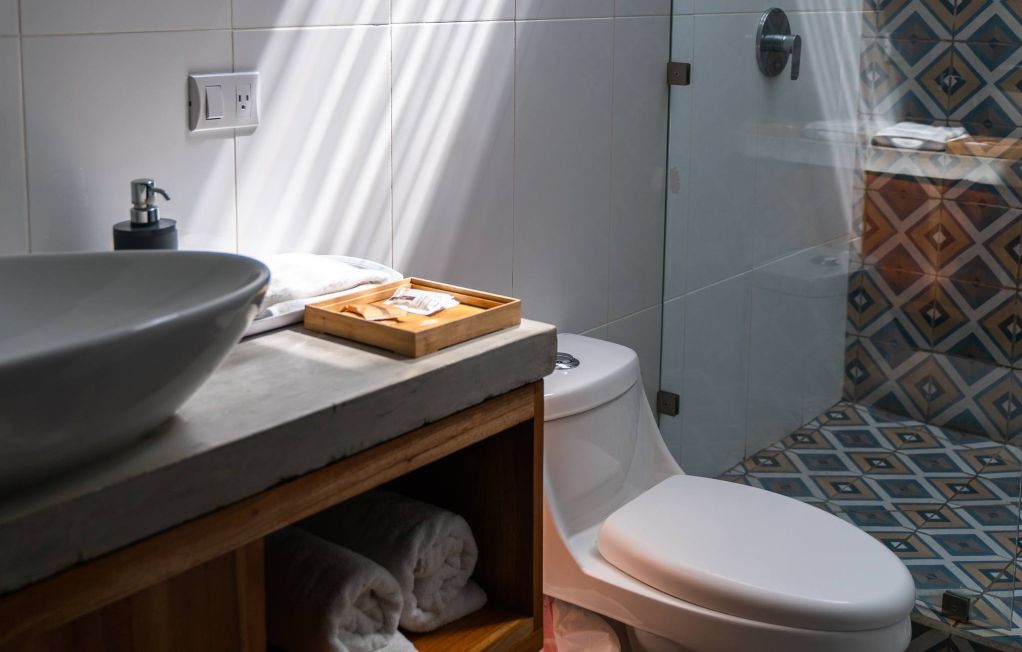 Hotel bathroom with white sink, toilet and tiled shower
