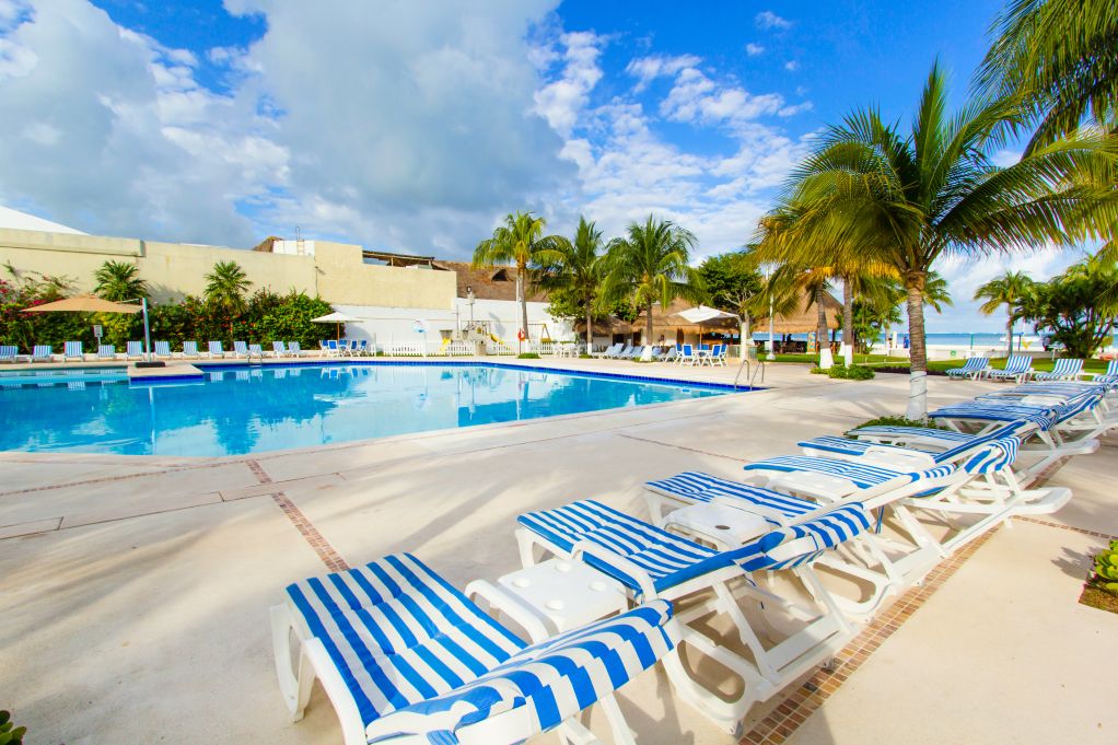Hotel pool in Cancun with stripey deckchairs