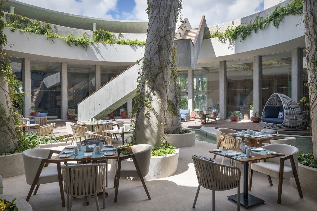 Outdoor restaurant with a tree at Cancun airport
